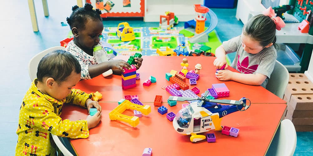 Children playing with colourful building bricks at the nursery