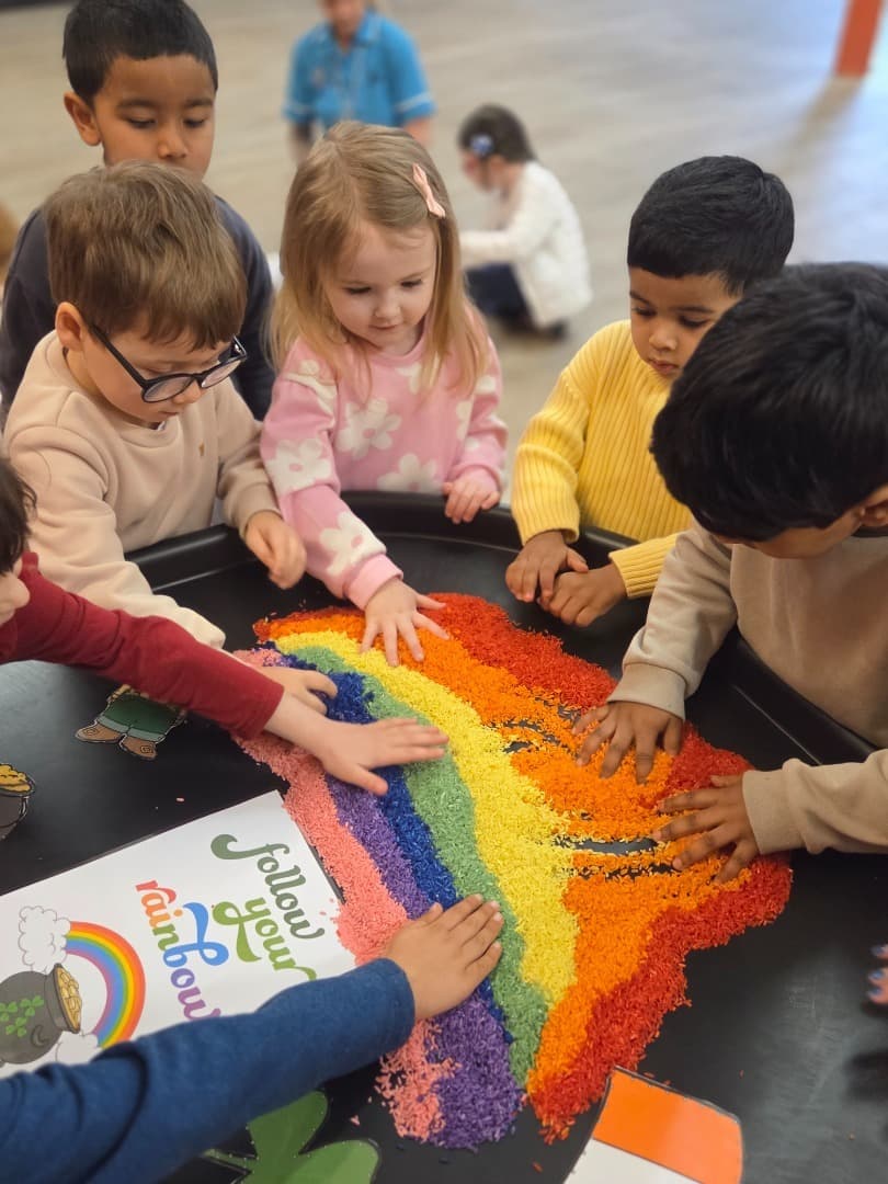 Children and a practitioner playing together at a table